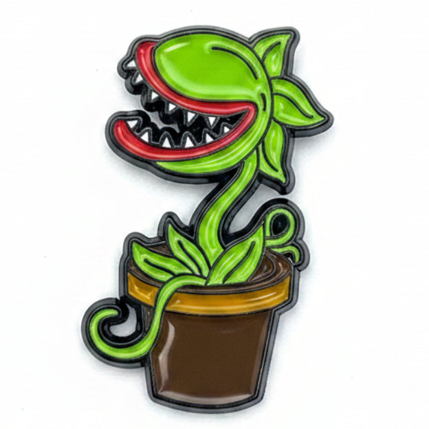 A stylized enamel pin or badge of the iconic Venus Flytrap plant from The Simpsons, featuring bright green leaves and trap heads with red interiors, black outlines, and a brown pot on a plain white background.