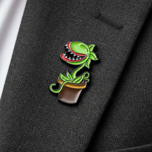 A small enamel pin shaped like a green Venus flytrap plant in a brown pot, pinned onto a dark charcoal gray suit jacket lapel next to a white shirt cuff.